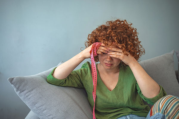 Woman worried about appearance holding a measure tape